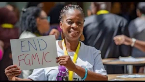 Rugiatu Nenneh Turay holding an "End FGM/C" sign during one of her awareness campaigns